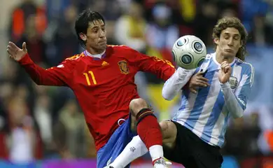 Spain's Joan Capdevilla (L) battles for the ball against Argentina's Fabrizio Coloccini during their friendly soccer match at the Vicente Calderon stadium in Madrid, November 14, 2009.     REUTERS/Nacho Doce (SPAIN SPORT SOCCER)
